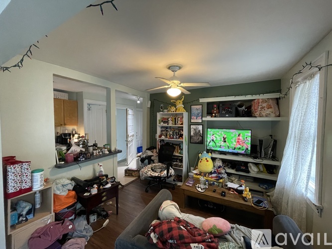 A messy room with a TV and a bed.