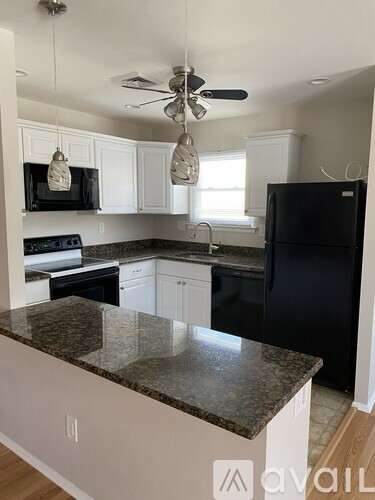 A kitchen with granite countertops and white cabinets.