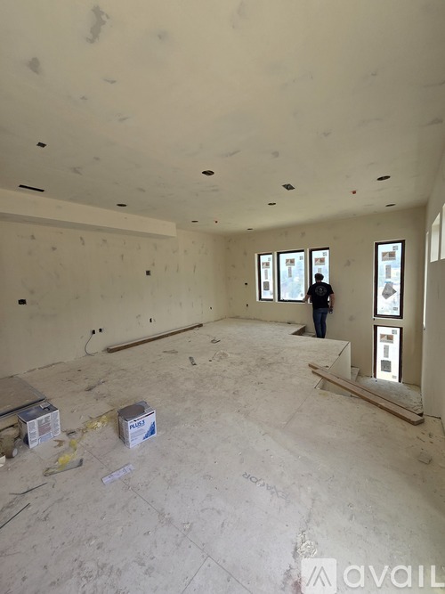 A man is standing in a room with drywall and insulation.