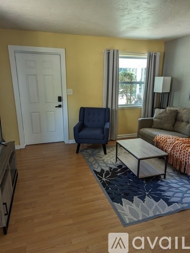 A living room with a blue chair and a white door.