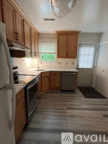 A kitchen with wooden cabinets and a white refrigerator.