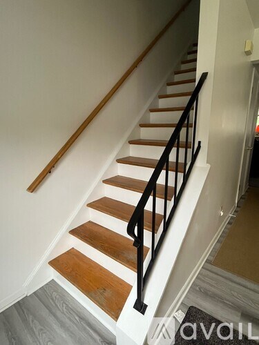 A staircase with wooden steps and black railings.