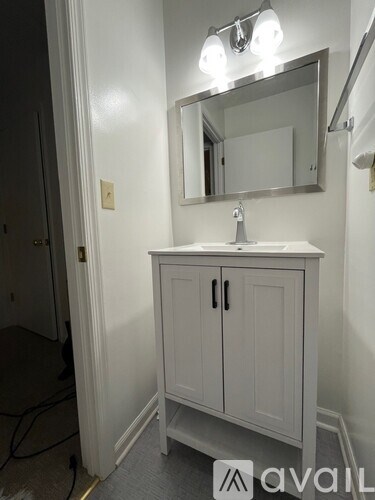 A bathroom with a sink and a mirror above it.