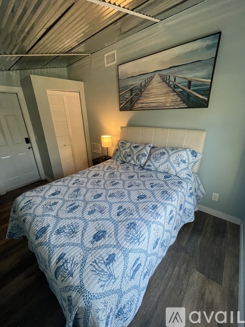 A bedroom with a bed covered in a blue and white patterned comforter.