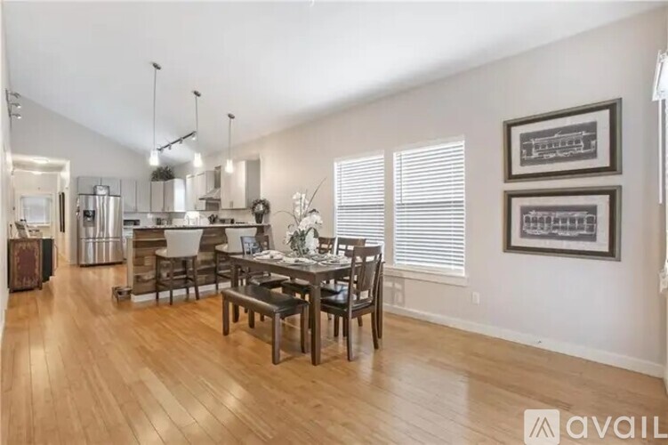 A kitchen with a dining table and chairs in the foreground.