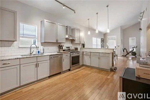 A kitchen with wooden floors and white cabinets.