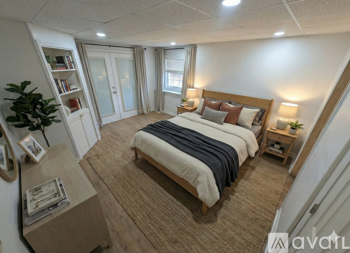 A bedroom with a large bed and a wooden nightstand.