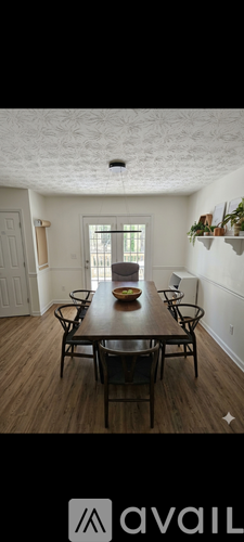 A dining room with a wooden table and chairs.