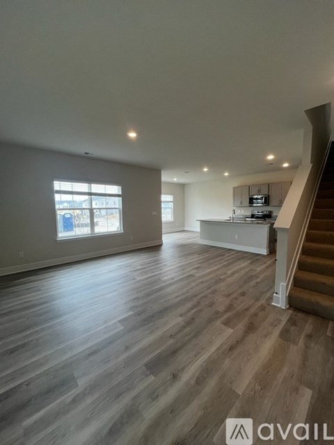 A spacious living room with a staircase leading to the upper floor.