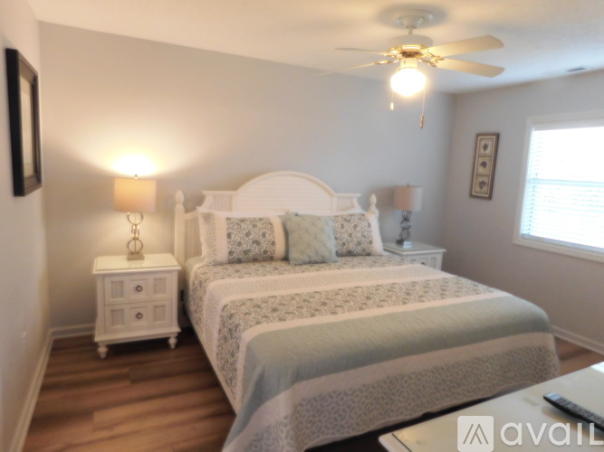 A bedroom with two beds and a ceiling fan.