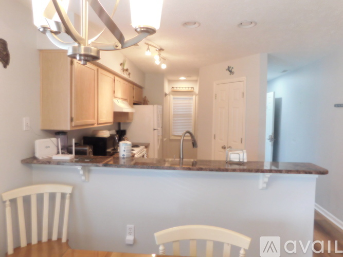 A kitchen with a white counter and two chairs.