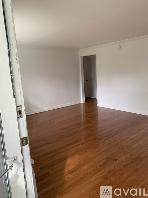 A room with wooden flooring and a white door.