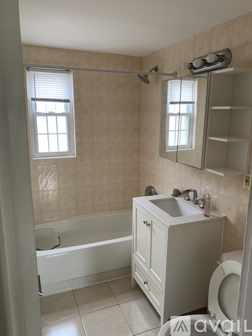 A bathroom with a white tub, sink, and toilet.