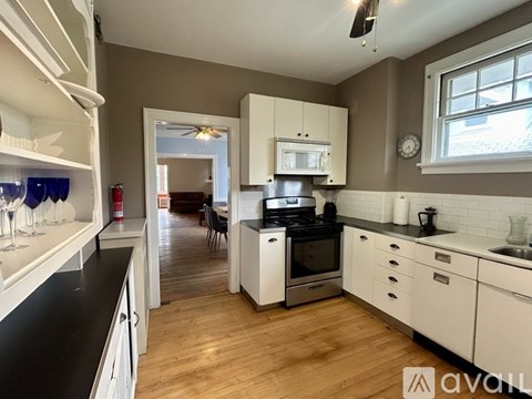 A kitchen with white cabinets and a black countertop.