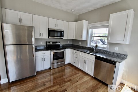 A kitchen with white cabinets and stainless steel appliances.