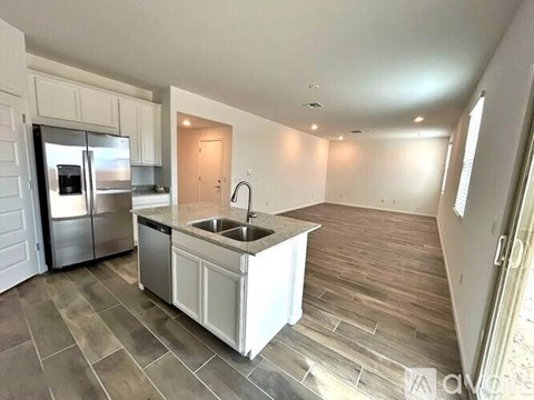 A kitchen with a sink and a refrigerator.