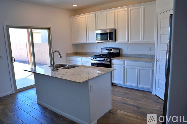 A kitchen with white cabinets and a granite countertop.