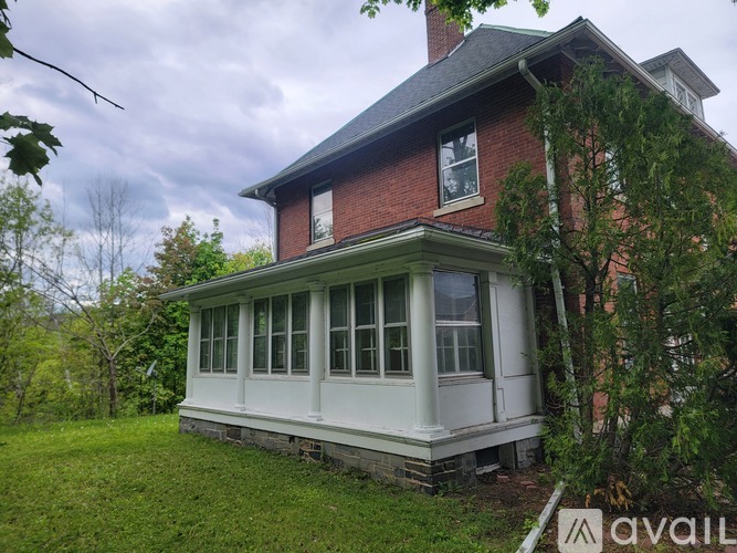 A house with a red brick exterior and a white porch.