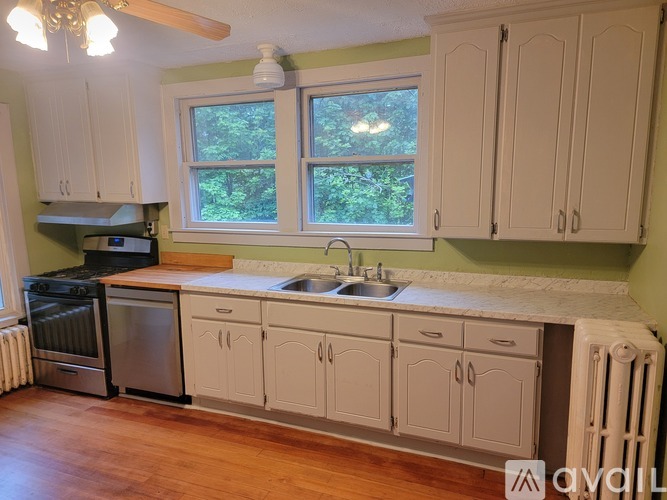 A kitchen with white cabinets and a window.