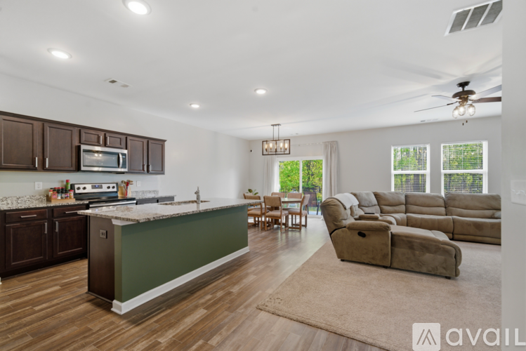 A modern kitchen with dark wood cabinets and a green island.