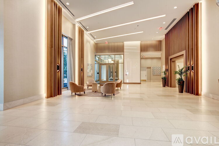 A spacious lobby with marble floors and wooden accents.