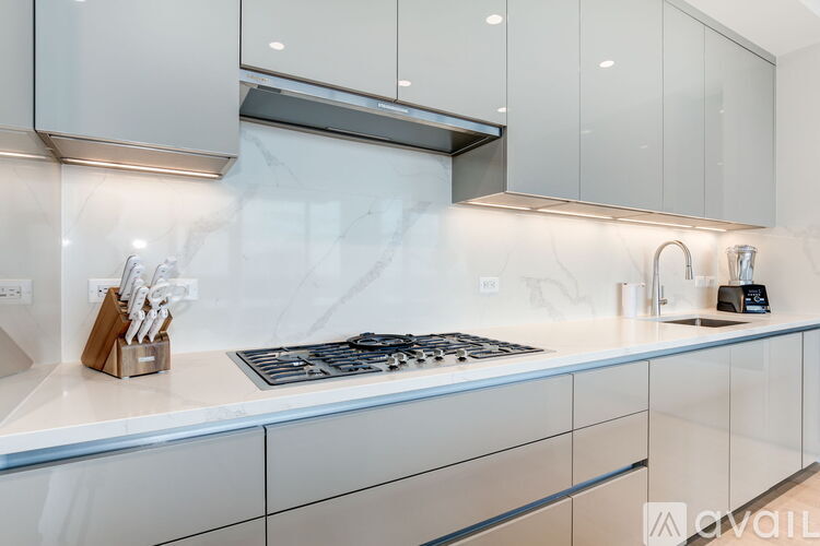 A modern kitchen with a white countertop and a stove top oven.