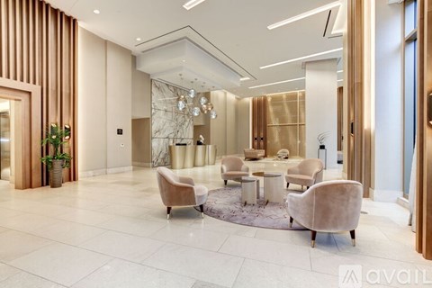 A modern living room with a glass chandelier and a round table with chairs.