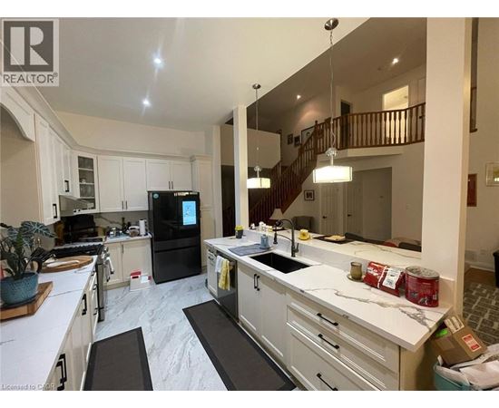 A kitchen with white cabinets and a black fridge.