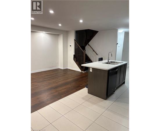 A modern kitchen with a wooden floor and white walls.