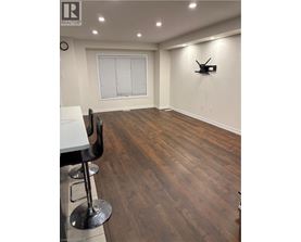 A room with wooden flooring and a white table with two chairs.