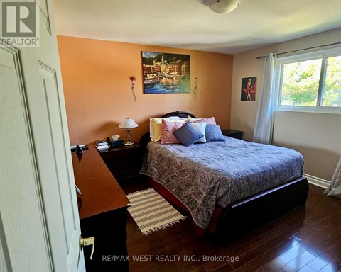 A bedroom with a bed, nightstand, and lamp.
