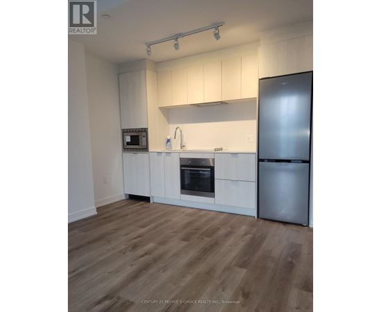 A kitchen with white cabinets and a wooden floor.
