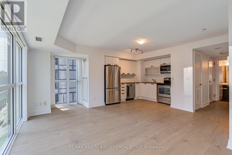 A spacious kitchen with white cabinets and stainless steel appliances.