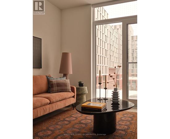 A living room with a couch, a table, and a window.