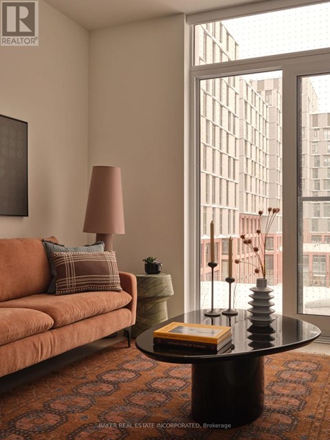 A living room with a couch, a table, and a window.