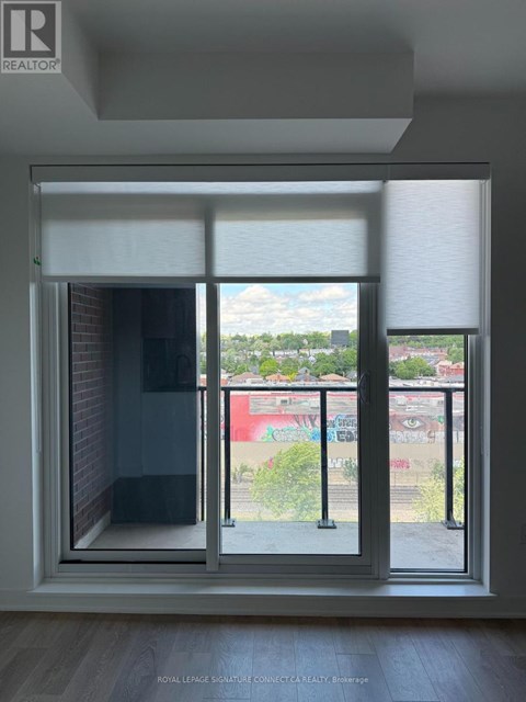 A window with a view of a graffiti covered wall outside.