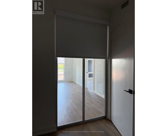 A room with a sliding door leading to a balcony.