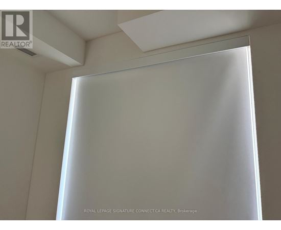 A white curtain in a room with a ceiling light.