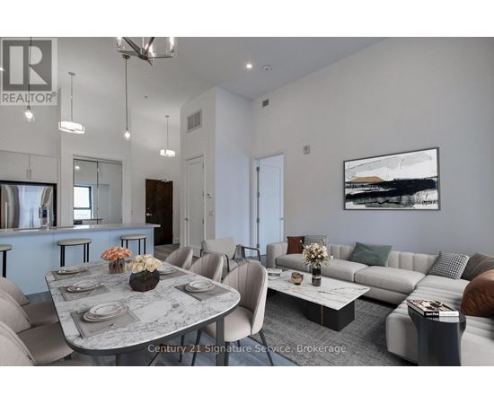 A modern living room with a grey sofa, a round table and a painting on the wall.