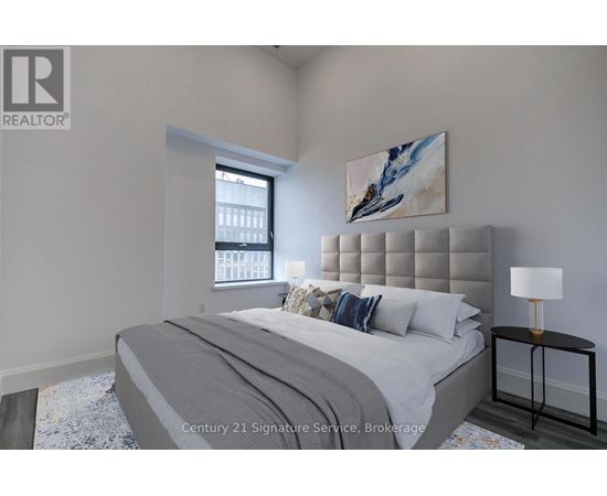 A bedroom with a large bed and a painting on the wall.