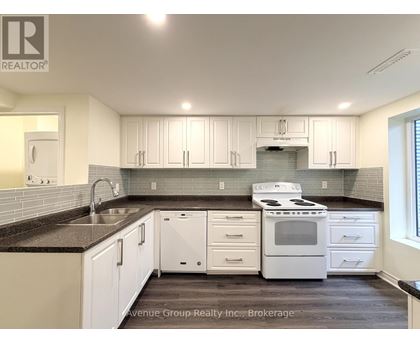 A kitchen with white cabinets and a black countertop.