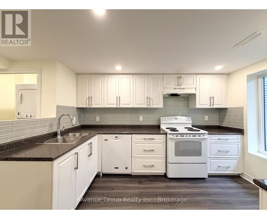 A kitchen with white cabinets and a black countertop.