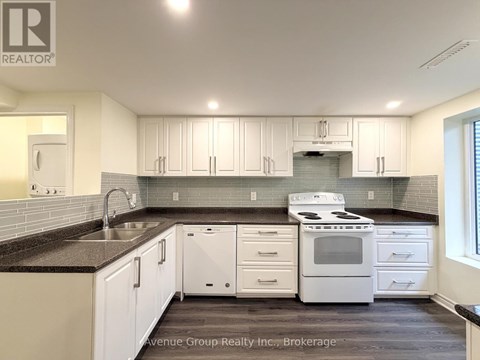 A kitchen with white cabinets and a black countertop.