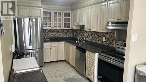 A kitchen with white cabinets and a black countertop.