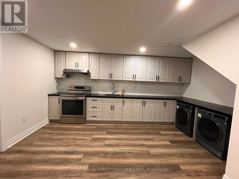 A kitchen with wooden floors and white cabinets.