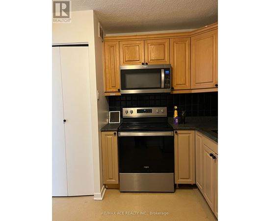 A kitchen with wooden cabinets and a black countertop.