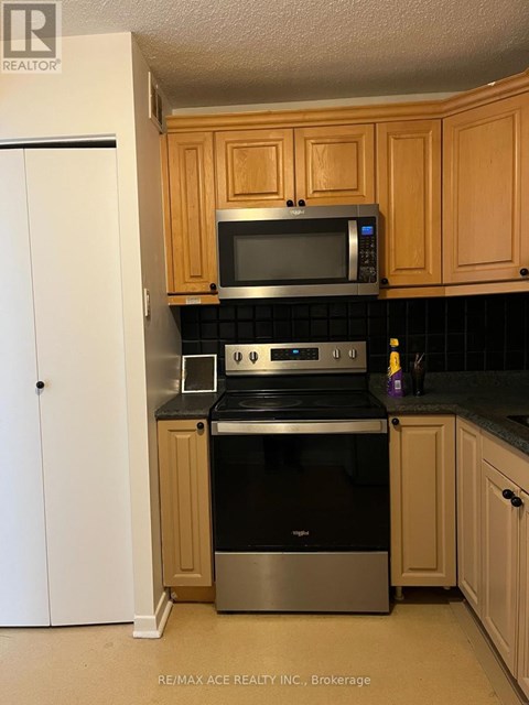 A kitchen with wooden cabinets and a black countertop.