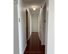 A long hallway with white walls and a light on.