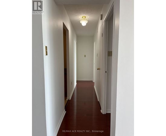 A long hallway with white walls and a light on.