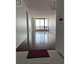 A hallway with a red doormat and a chandelier.